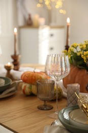 Photo of Stylish table setting with beautiful dishware, glasses and autumn decor in dining room