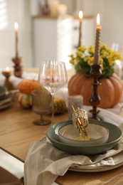 Stylish table setting with beautiful dishware, glasses and autumn decor in dining room