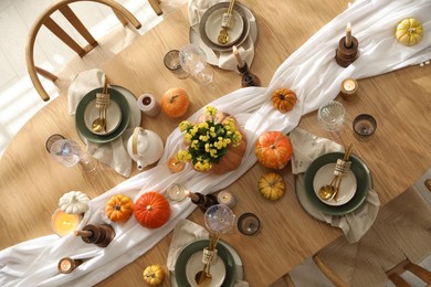 Stylish table setting with beautiful dishware, glasses and autumn decor in dining room, top view