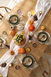 Stylish table setting with beautiful dishware, glasses and autumn decor in dining room, top view