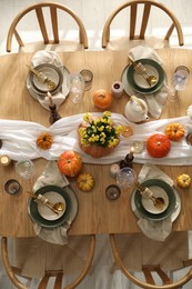 Photo of Stylish table setting with beautiful dishware, glasses and autumn decor in dining room, top view