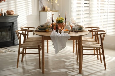 Photo of Stylish dining room with beautiful table setting and autumn decor