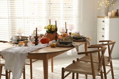 Photo of Stylish dining room with beautiful table setting and autumn decor