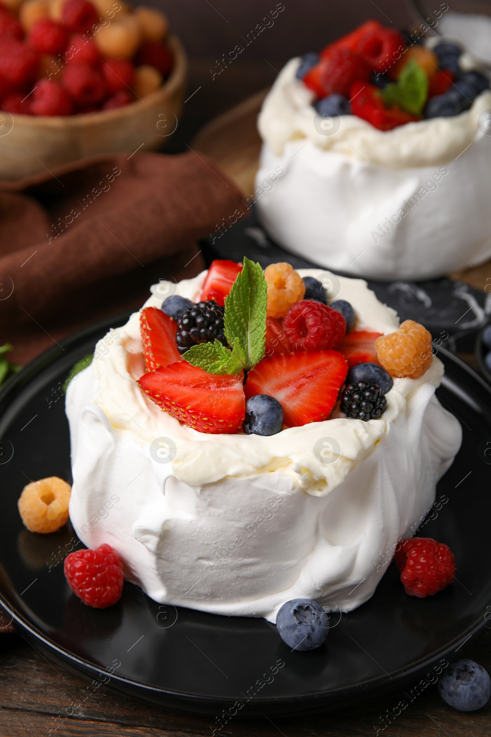 Photo of Pavlova cake (meringue dessert) with whipped cream, fresh berries and mint on table, closeup