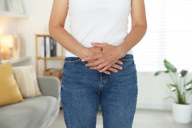 Menopause. Woman suffering from abdominal pain at home, closeup