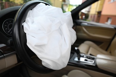 Photo of Opened airbag in automobile, closeup. Car safety equipment