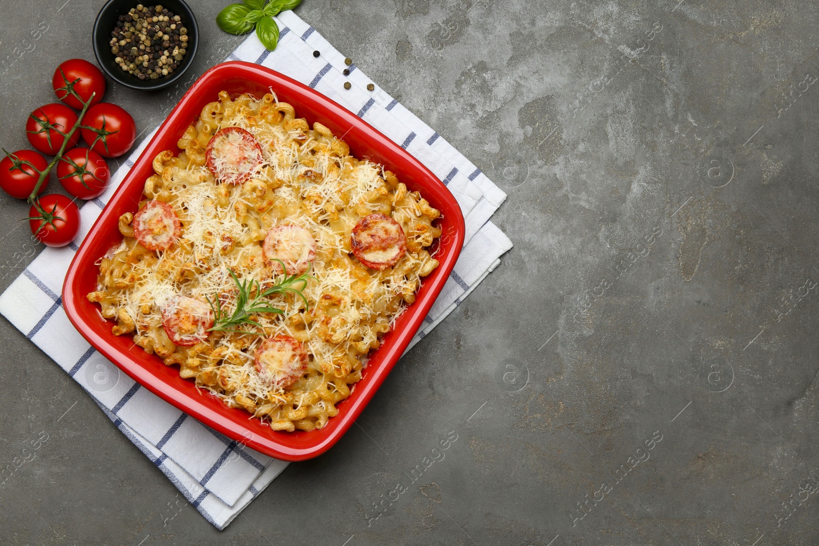 Photo of Delicious al forno pasta in baking dish on grey table, flat lay. Space for text