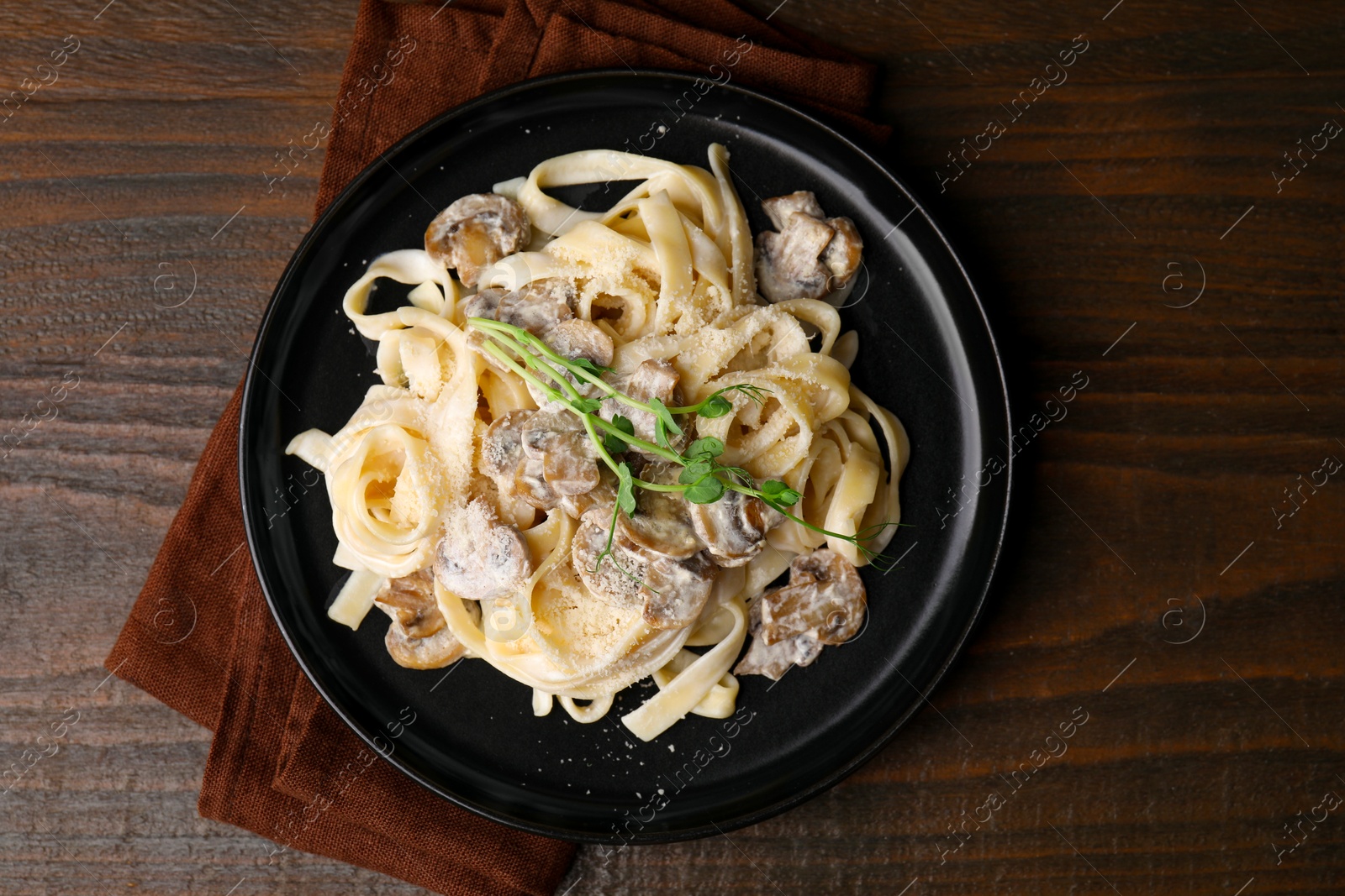 Photo of Delicious pasta with mushrooms on wooden table, top view