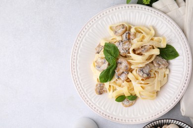 Photo of Delicious pasta with mushrooms and basil on light table, flat lay. Space for text