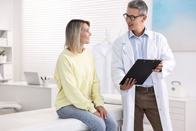 Healthcare worker with clipboard and patient in hospital