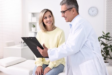 Healthcare worker with clipboard and patient in hospital