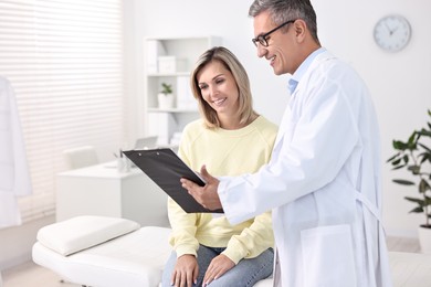 Photo of Healthcare worker with clipboard and patient in hospital