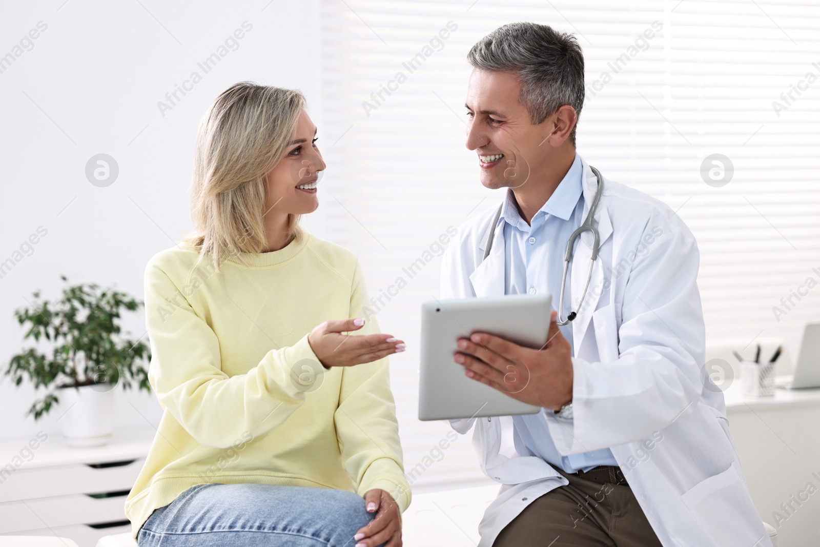 Photo of Healthcare worker with tablet and patient in hospital