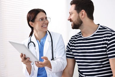 Photo of Healthcare worker with tablet and patient in hospital