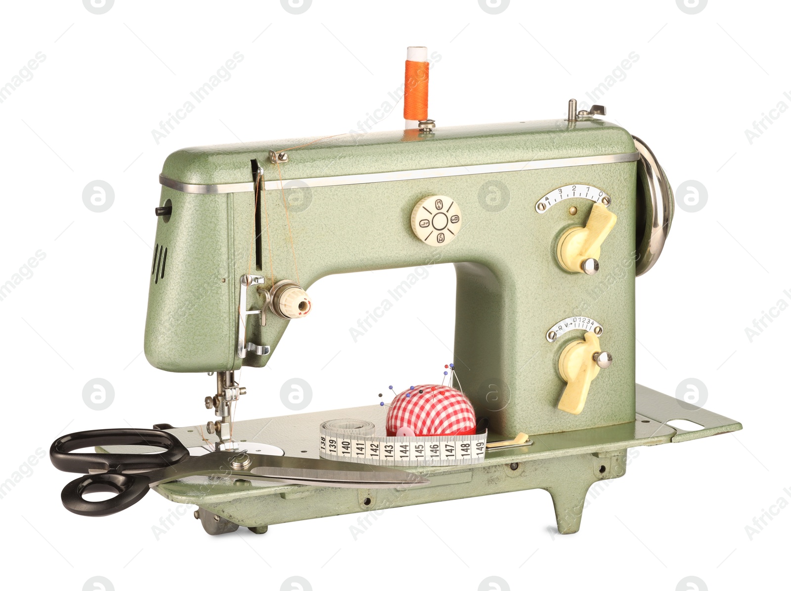 Photo of Sewing machine, measuring tape, scissors, pincushion and spool of thread isolated on white