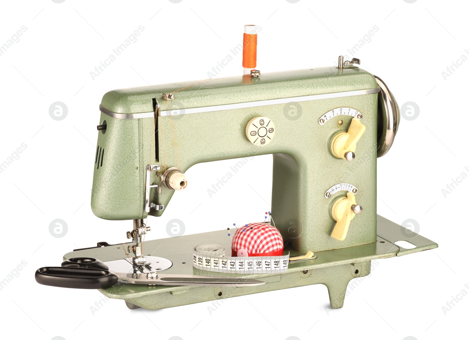 Photo of Sewing machine, measuring tape, scissors, pincushion and spool of thread isolated on white