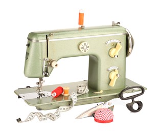 Photo of Sewing machine, measuring tape, scissors, pincushion and spools of threads isolated on white