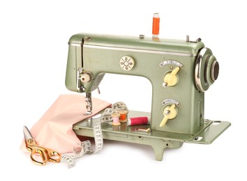 Photo of Sewing machine with pink fabric, measuring tape, scissors and spools of threads isolated on white