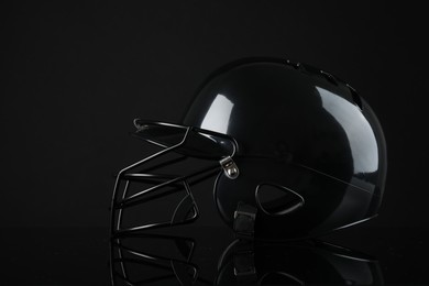 Photo of One modern baseball helmet on black background