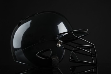 Photo of One modern baseball helmet on black background