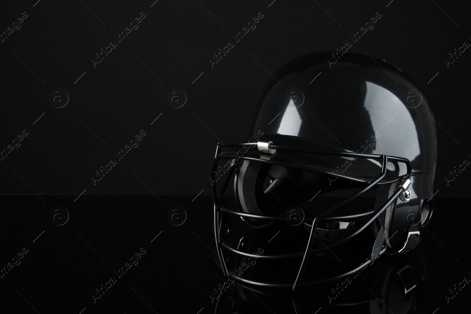 Photo of One baseball helmet on black background, space for text