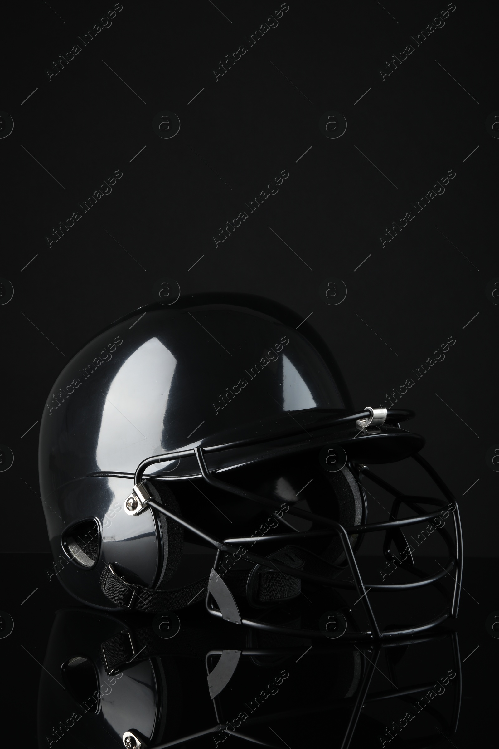 Photo of One modern baseball helmet on black background