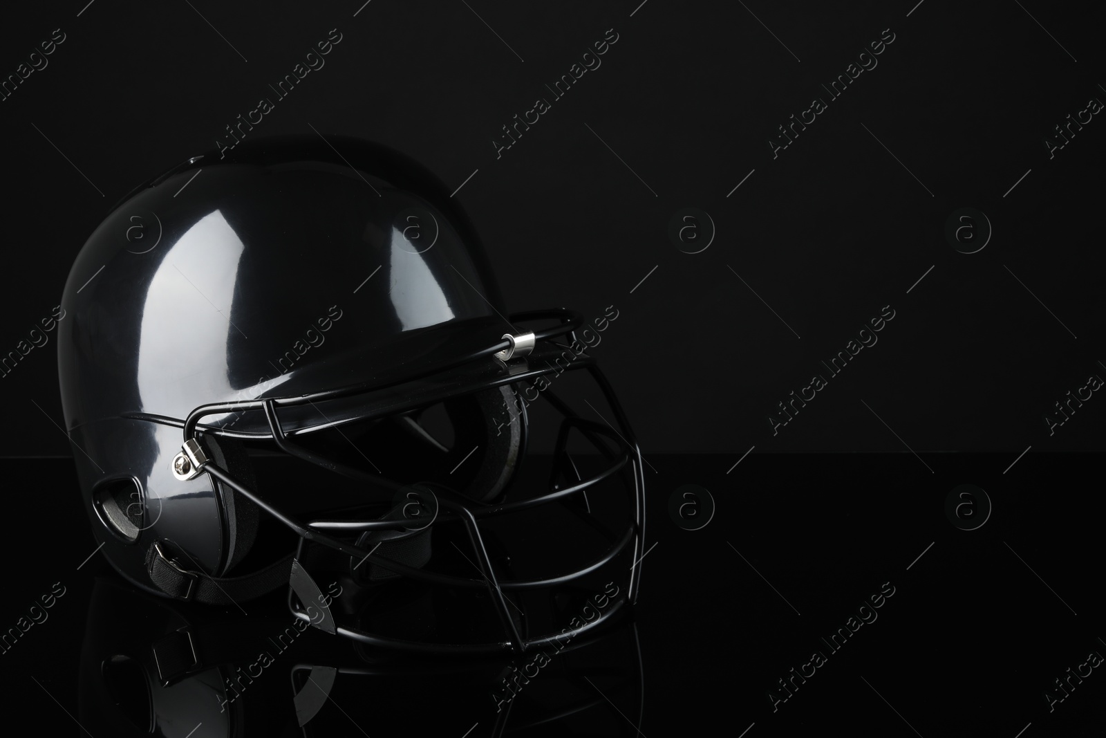 Photo of One baseball helmet on black background, space for text