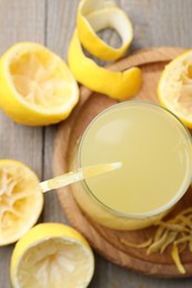 Photo of Glass of fresh juice and fruits on wooden table, flat lay