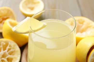 Glass of fresh juice and fruits on wooden table, closeup