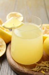 Photo of Glass of fresh juice and fruits on wooden table, closeup