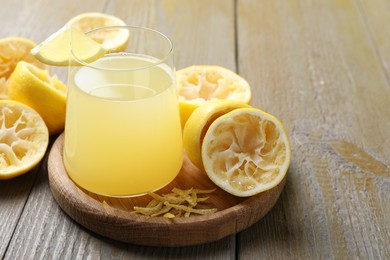 Photo of Glass of fresh juice and fruits on wooden table, closeup