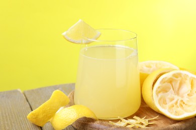 Glass of fresh juice and fruits on wooden table, closeup