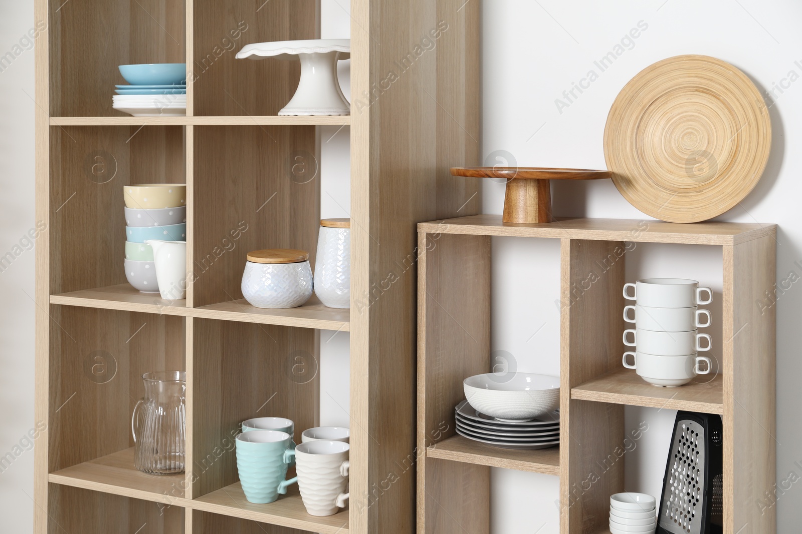 Photo of Wooden shelving units with kitchenware on white background