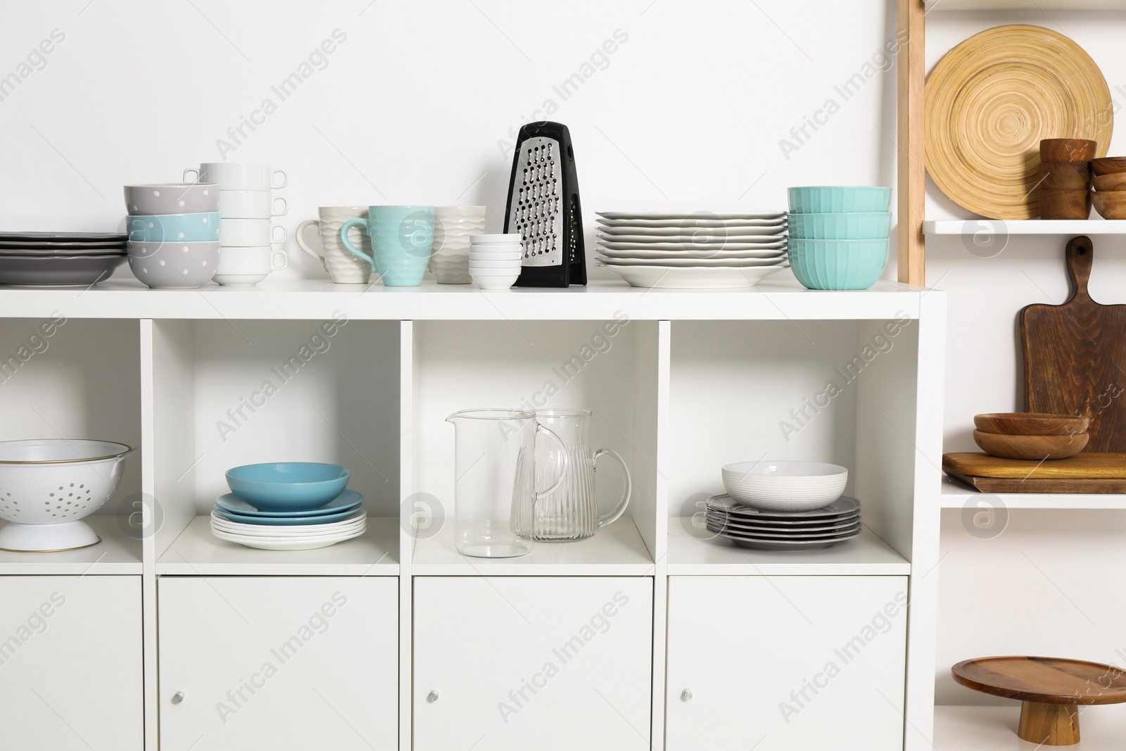 Photo of Storage cabinet with kitchenware near white wall indoors