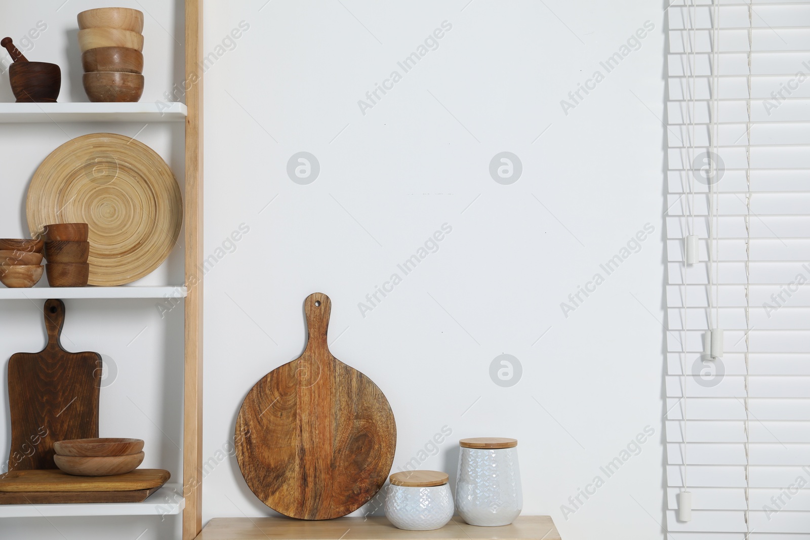 Photo of Storage stand with kitchenware near white wall indoors