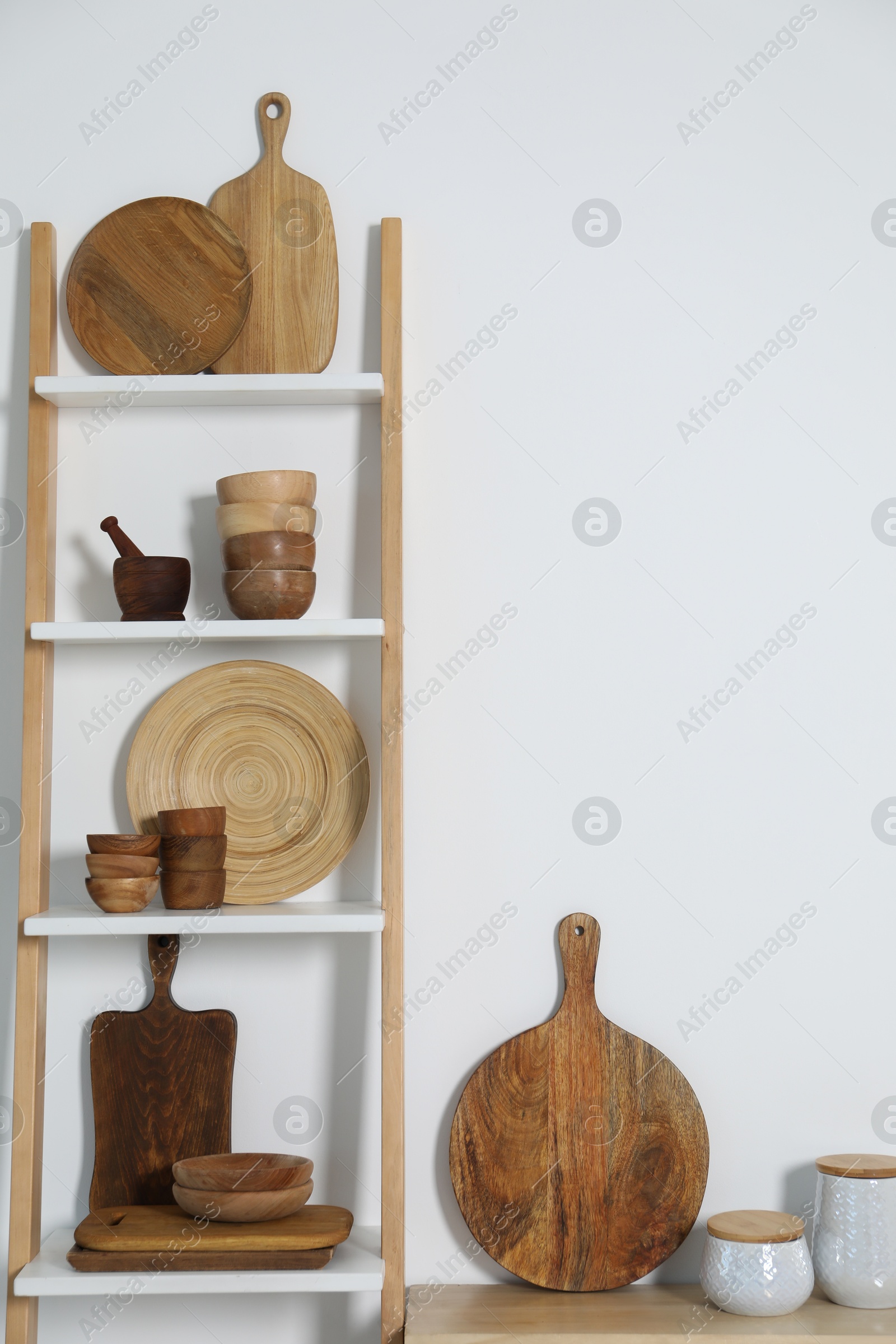 Photo of Storage stand with kitchenware near white wall indoors