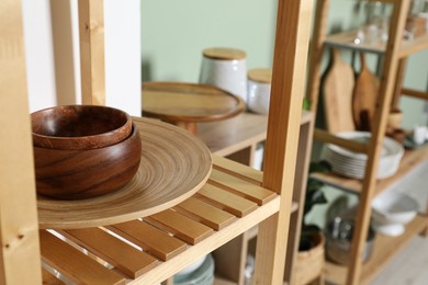 Photo of Wooden storage stands with kitchenware indoors, closeup