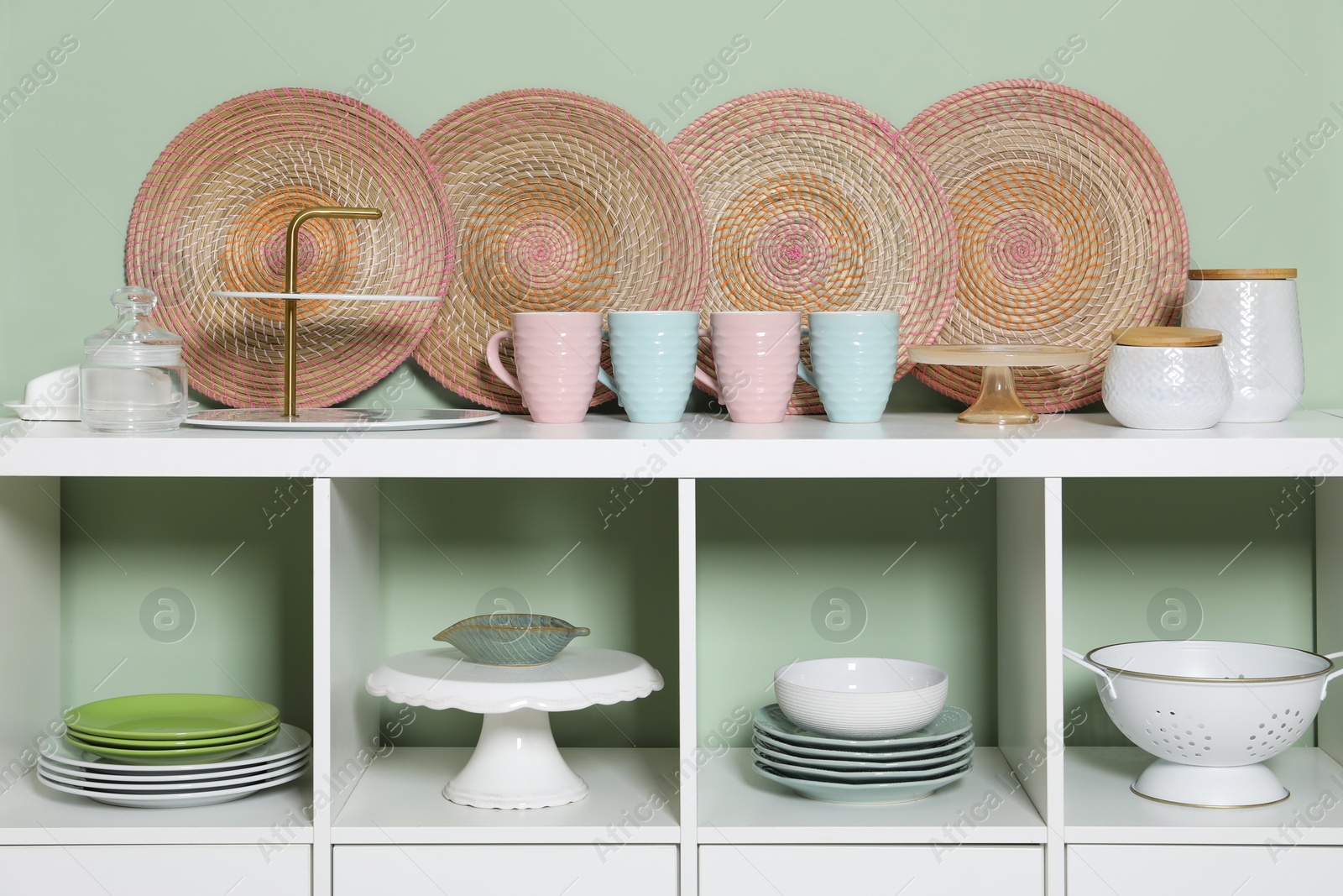 Photo of Storage cabinet with kitchenware near green wall