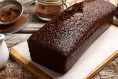 Photo of Tasty chocolate sponge cake on wooden table, closeup