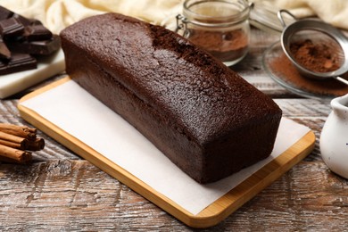 Photo of Tasty chocolate sponge cake on wooden table, closeup