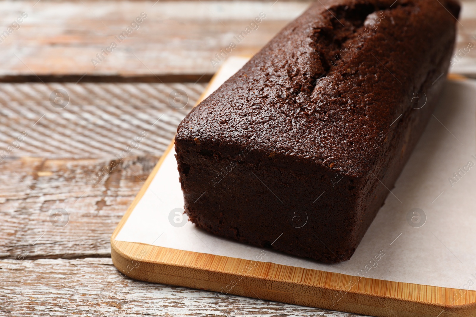 Photo of Tasty chocolate sponge cake on wooden table, closeup