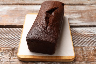 Photo of Tasty chocolate sponge cake on wooden table, closeup