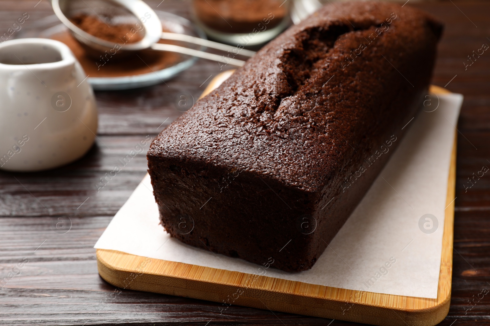 Photo of Tasty chocolate sponge cake on wooden table, closeup