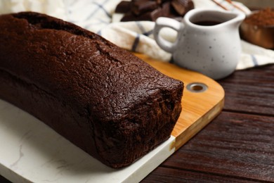 Photo of Tasty chocolate sponge cake on wooden table, closeup