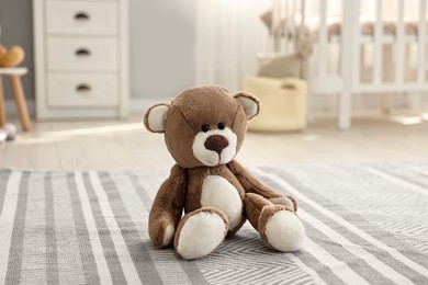 Photo of Cute teddy bear on floor in child room