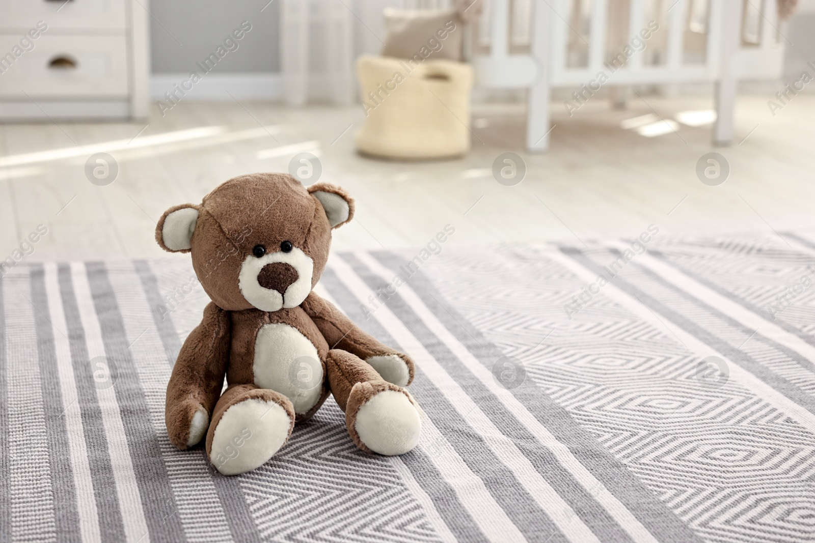 Photo of Cute teddy bear on floor in child room, space for text