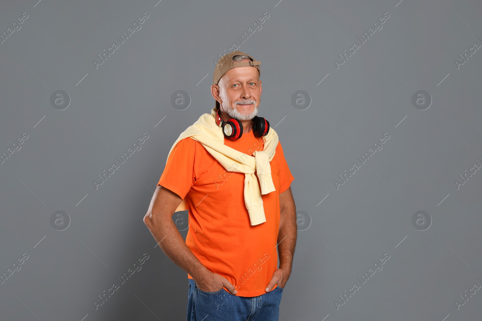 Photo of Portrait of handsome senior man with headphones on grey background