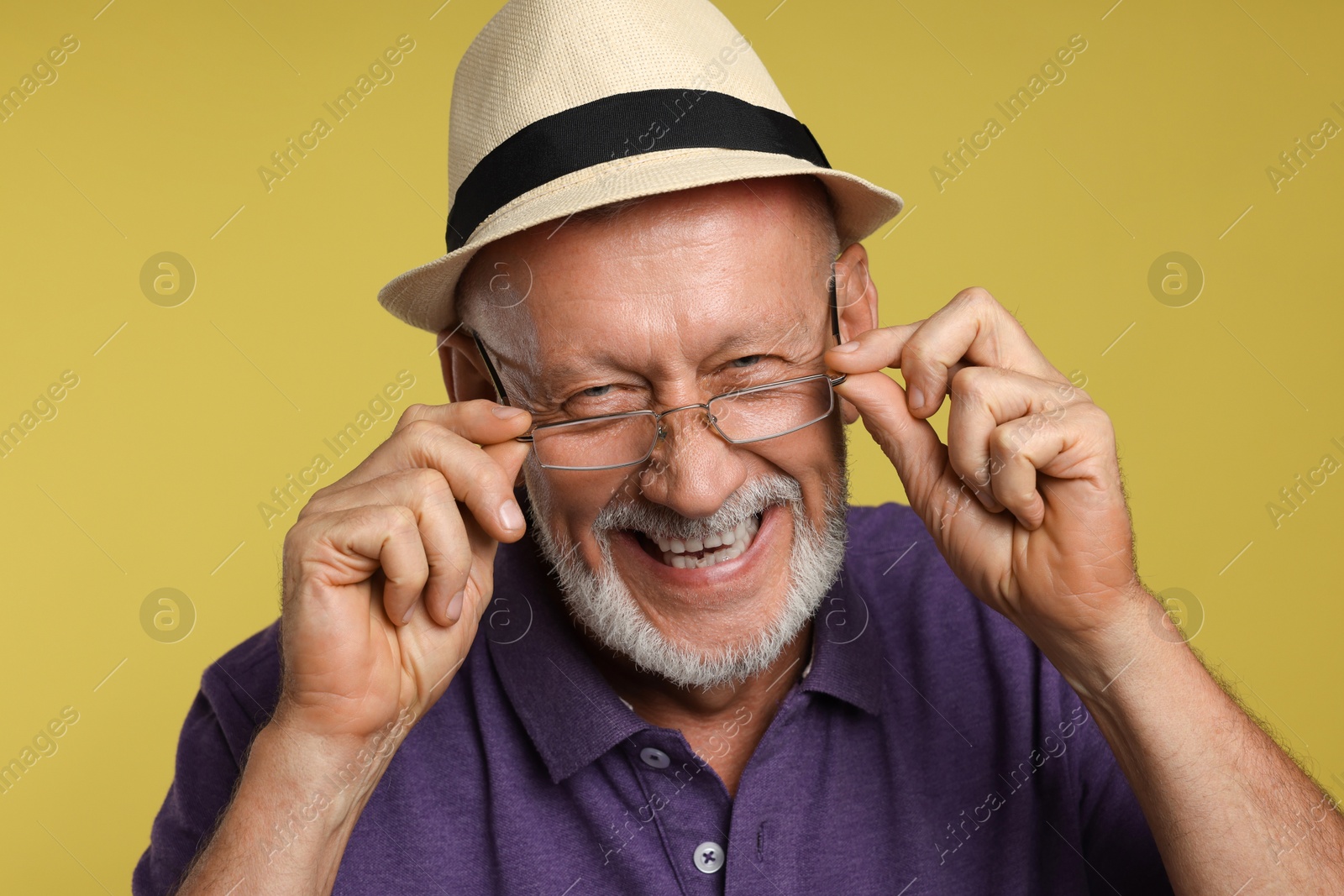 Photo of Portrait of happy senior man on yellow background