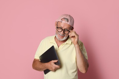 Photo of Portrait of handsome senior man with laptop on pink background