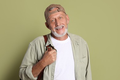 Photo of Portrait of happy senior man with backpack on green background